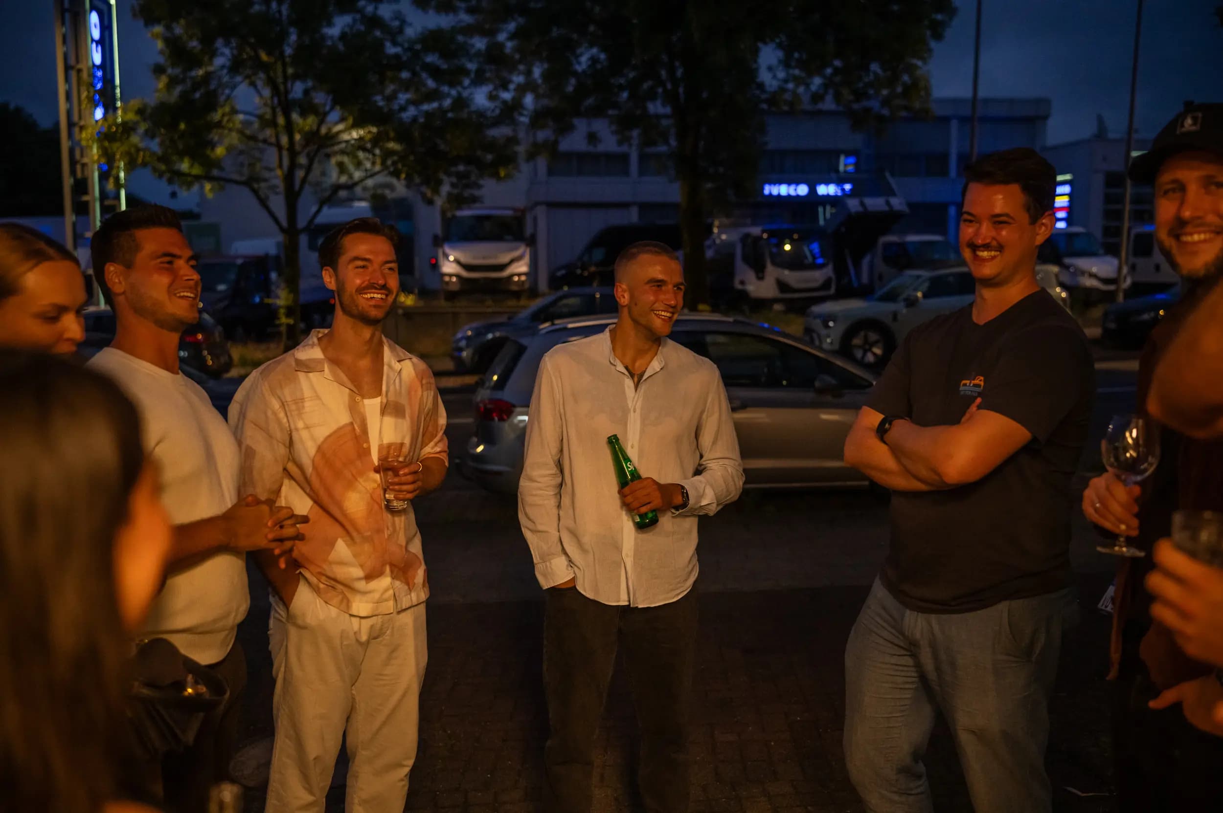 Gäste lachen und feiern am Abend vor der neuen Praxis in Eilendorf
